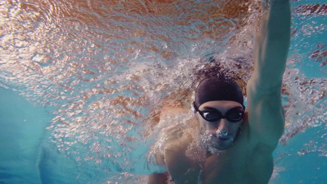 带眼镜的专业游泳运动员在自由泳池中跳跃和跳水。视频下载