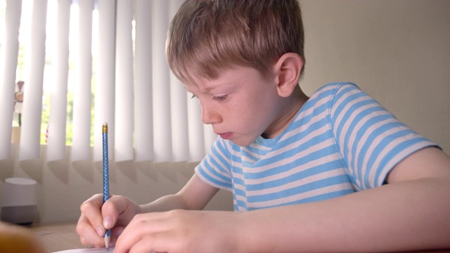 男孩正在家里用铅笔解决纸上的迷宫。视频素材