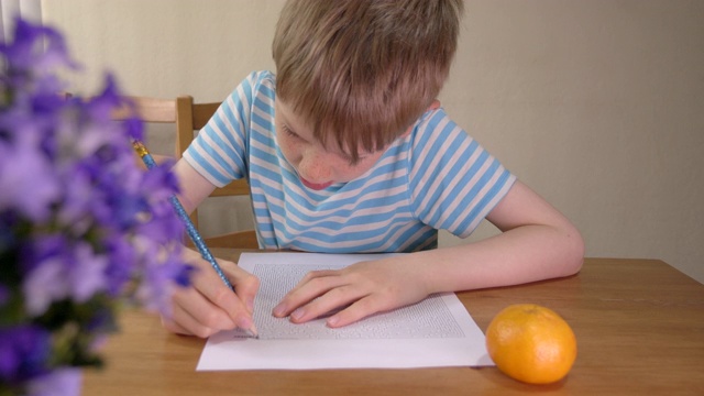 男孩正在家里用铅笔解决纸上的迷宫。视频素材
