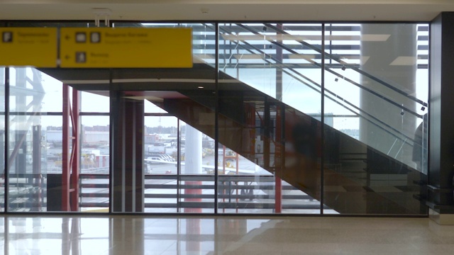 离港机场大厅设有自动扶梯和窗口背景视频素材