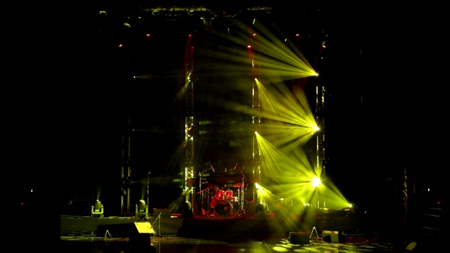 黑暗中空荡荡的舞台上，七彩的灯光闪烁着白色的光芒。视频素材