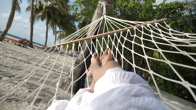 观点女人的腿在沙滩上的暑假吊床上放松视频素材