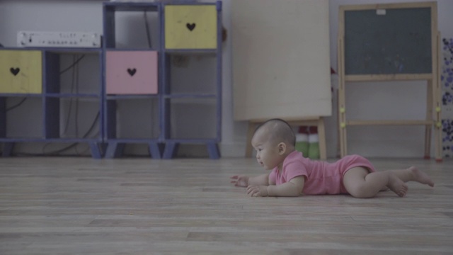 小女孩在家里的木地板上爬行/重庆，中国视频素材