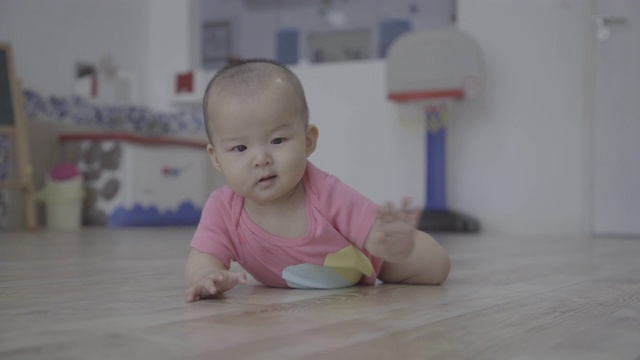 小女孩在家里的木地板上爬行/重庆，中国视频素材
