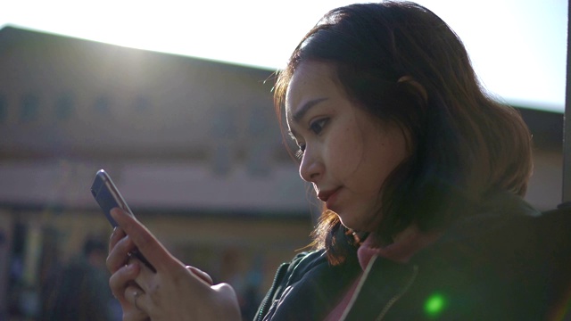 一个在日落时使用手机的女人视频素材