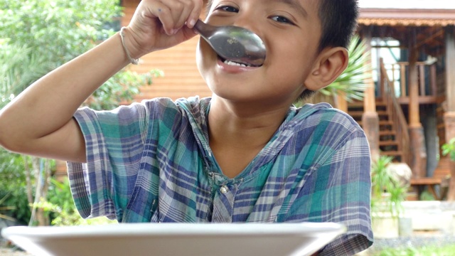 亚洲小男孩在家里吃米饭视频素材