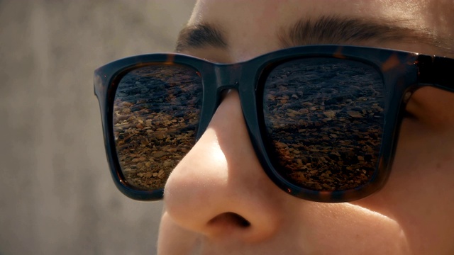 Cinemagraph -一个戴着太阳镜的女人与海岸的反射视频下载