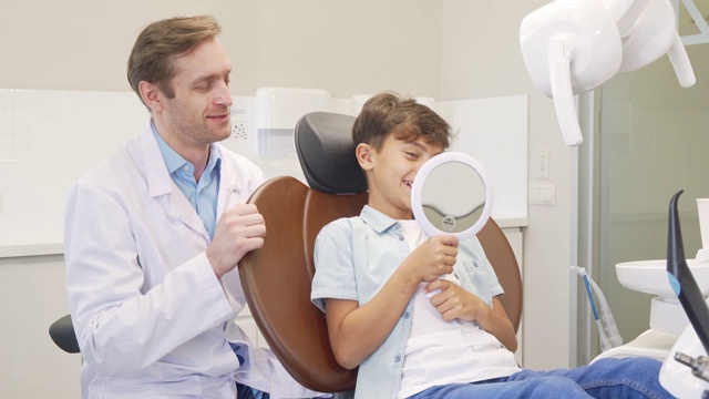 可爱的男孩在检查完牙齿后对着镜子检查他的健康牙齿视频素材