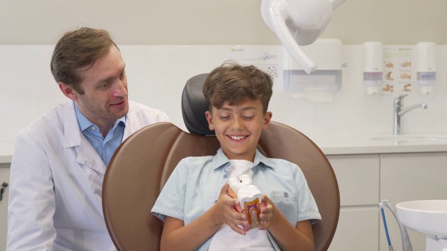快乐的小男孩在牙科检查成功后竖起大拇指视频素材