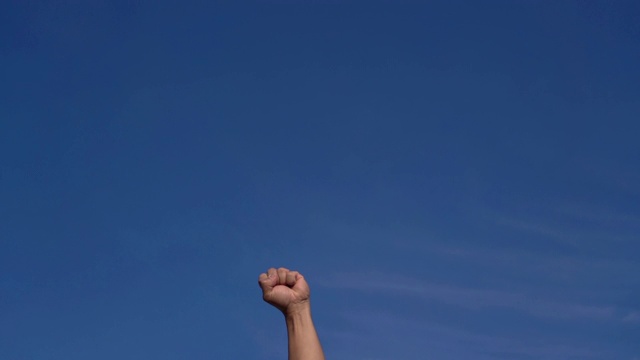 人拳的SLO MO在蓝天的空气中视频下载