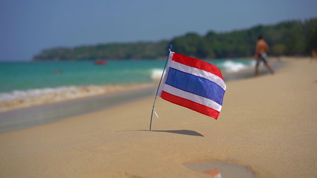 在一个美丽的海滩上的泰国国旗的超慢速镜头。热带度假的概念。泰国之旅概念视频下载