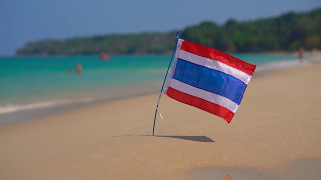 一个美丽的海滩上的泰国国旗的特写镜头。热带度假的概念。泰国之旅概念视频下载
