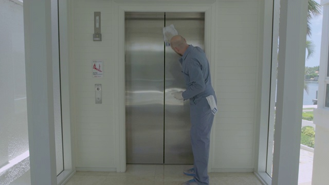 门卫负责接近、清洁和擦亮电梯门视频素材