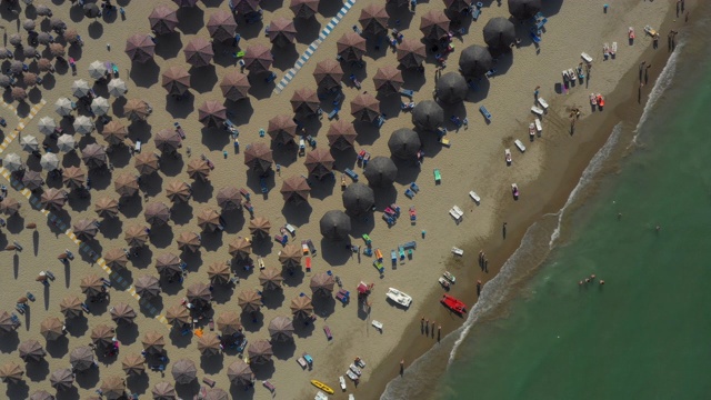 无人机镜头的亚得里亚海海岸在一个角度移动内陆揭示人们放松在佩斯卡拉的海滩，意大利。视频素材