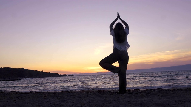 一个女人在日落时分练瑜伽视频素材
