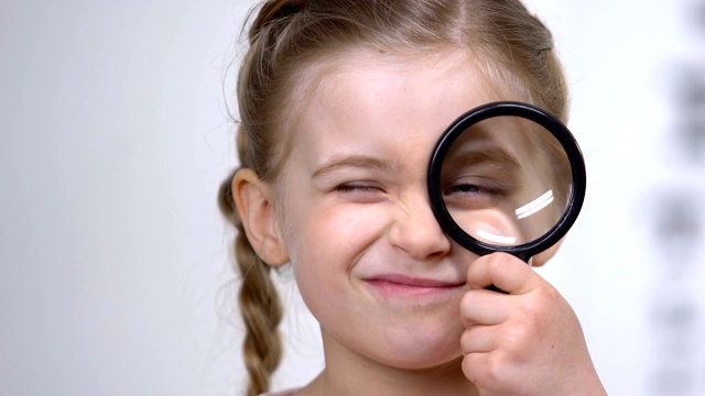 古玩女小孩透过放大镜看，检查视力，健康视频下载