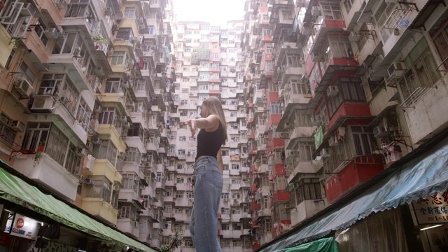 慢镜头:一个女孩在中国香港的公寓里听音乐视频下载