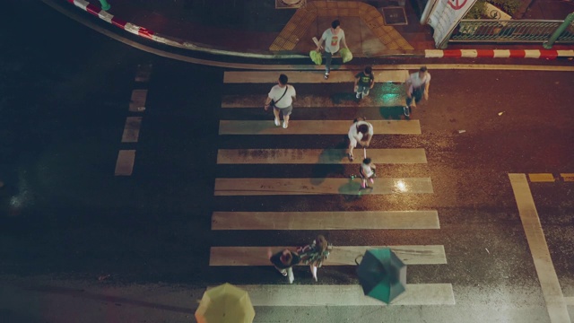 俯视图;行人人群在雨夜穿过人行横道视频下载