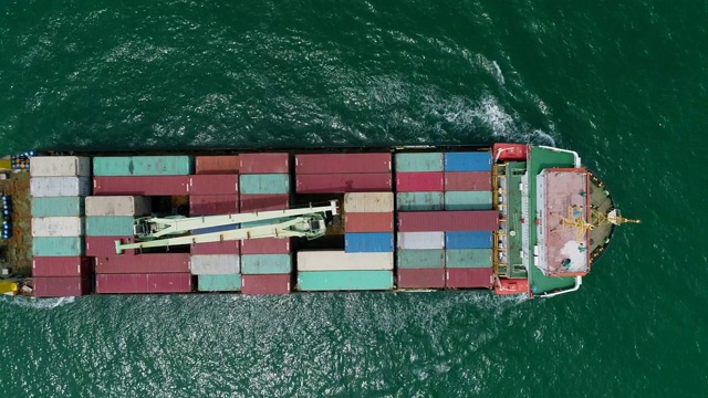 鸟瞰图集装箱船满载集装箱在绿海上物流，航运，进出口或运输。视频素材