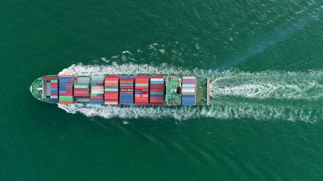 鸟瞰图集装箱船满载集装箱在绿海上物流，航运，进出口或运输。视频素材
