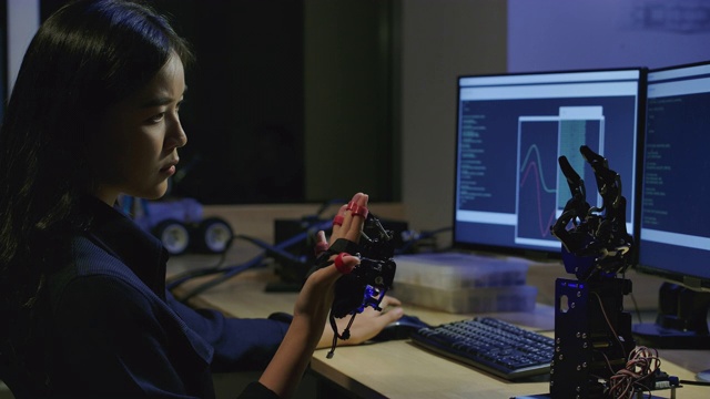 年轻的电子开发工程师在实验室测试创新机器人技术。年轻的亚洲女性为机械机械手创造运动。有技术或创新观念的人。视频下载