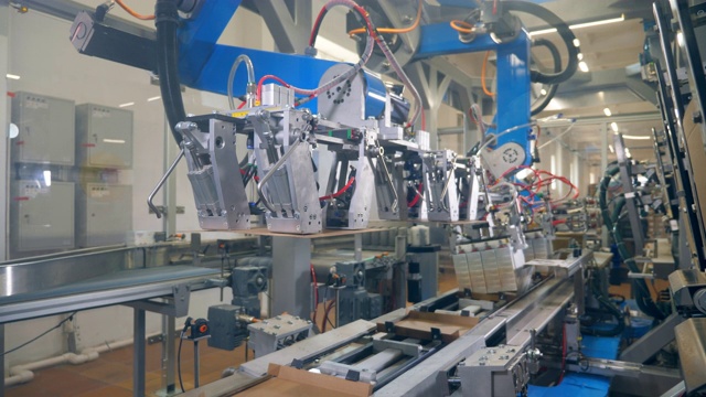 工厂用机器把纸板放在传送带上做成盒子。自动化生产线。视频素材