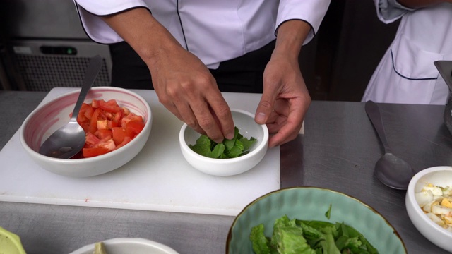 一个面目全非的厨师正在准备沙拉的特写视频素材