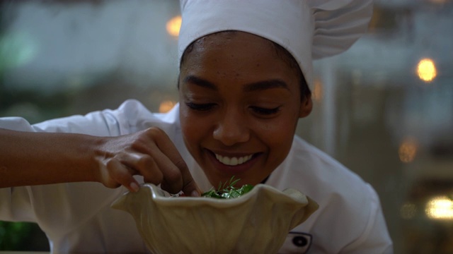 友善的黑人厨师面带微笑为沙拉做最后一笔视频素材