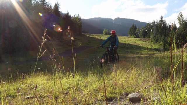 山地摩托车手沿着山路穿过山林视频素材