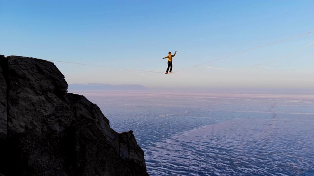 一个年轻女子在高高的吊索上行走。视频下载