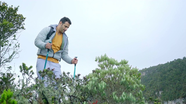 一个拉丁人在登山杖的帮助下下山。视频下载