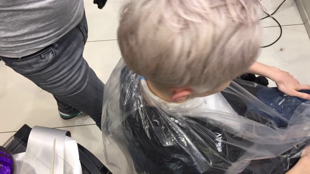 男性理发师梳理和准备年轻人的头发染发视频素材