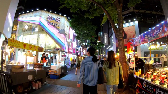 明洞市场的超延时。韩国首尔，人们晚上走在购物街上视频下载