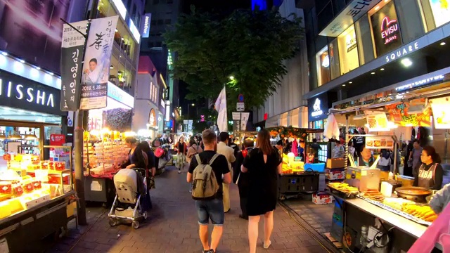 明洞市场的超延时。韩国首尔，人们晚上走在购物街上视频下载