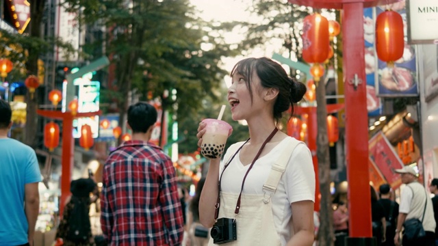 台湾千禧女喝着珍珠奶茶走在西门町购物区(慢镜头)视频下载