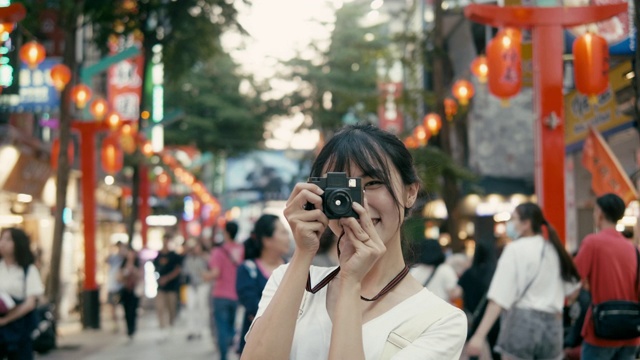 台湾千禧一代女性在西门町购物区用复古相机拍照(慢镜头)视频下载