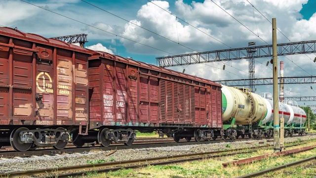 一列货车在火车站的背景云和蓝色的天空。2019年6月，哈萨克斯坦努尔苏丹阿拉木图。间隔拍摄4 k视频下载