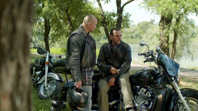 两个人骑完摩托车后正在休息视频素材