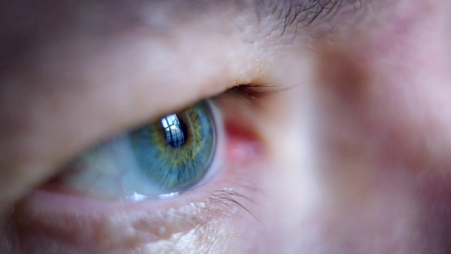 近距离微距拍摄的中年男性人类蓝色眼睛闪烁在慢动作。视频下载