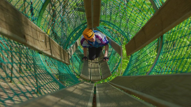 一个人在一个悬挂的网状隧道里视频下载