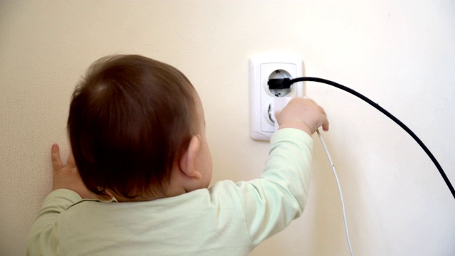 婴儿到达电源插座和从充电器拔掉usb线，危险的不安全在家里视频素材