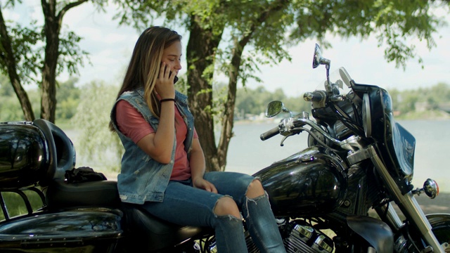 坐在摩托车上聊天的可爱女孩视频下载