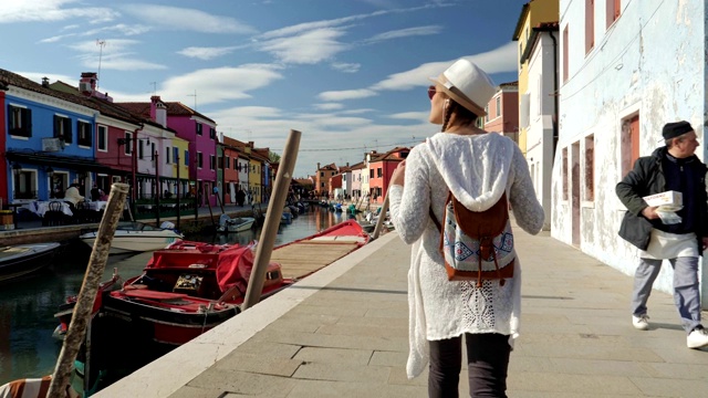独自旅行者，年轻的女游客漫步在布拉诺岛，威尼斯，意大利。浪漫之都，典型的威尼斯风情。视频素材