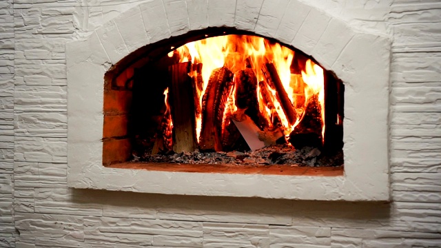 在家里舒适的壁炉里燃烧木头。壁炉作为一件家具视频素材