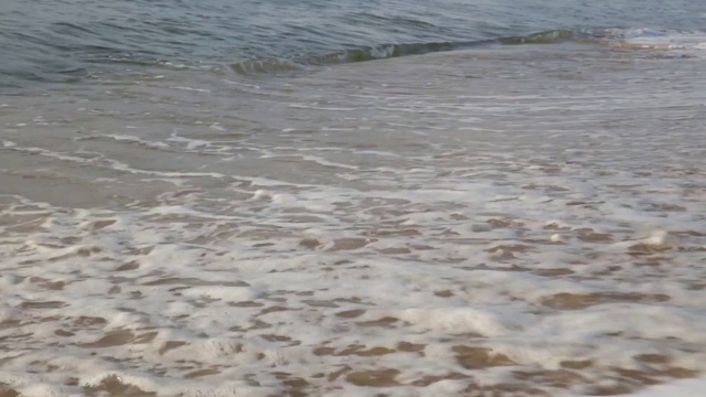 海浪冲走了沙滩上的脚印视频素材