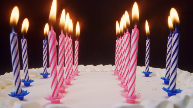 在生日蛋糕的蜡烛和一个关掉蜡烛的人之间的超级幻灯片。视频素材