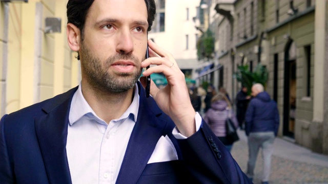 在城市里，一个商人接听电话，发送信息和微笑，为美丽的工作消息。视频素材