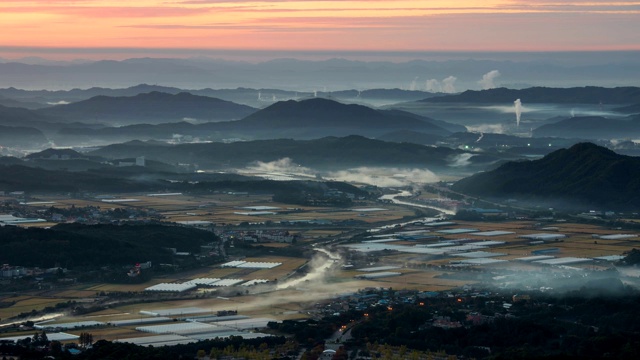 在韩国忠清南道的天安，秋色的农地周围的鹤城山和三邦川与湿雾视频素材