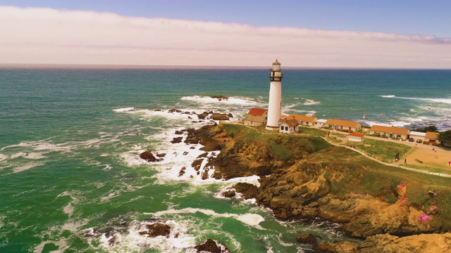 灯塔无人机拍摄空中直升飞机查看海岸与撞击的海浪日落4K视频素材