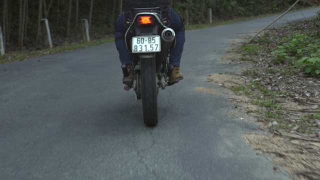 摩托车手骑着摩托车在路上行驶。在乡村道路上骑摩托车的人。摩托车旅行。运动的生活方式视频素材